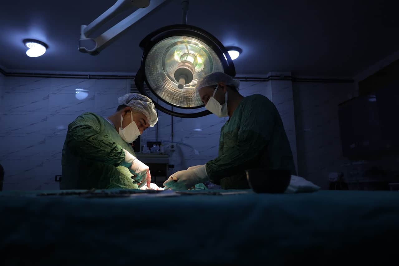 Surgeons performing an operation in a dark operating theatre